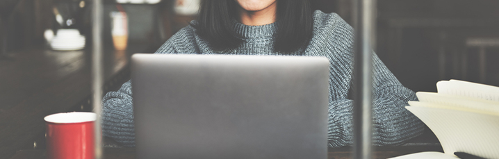 Woman working at a laptop in a coffee shop