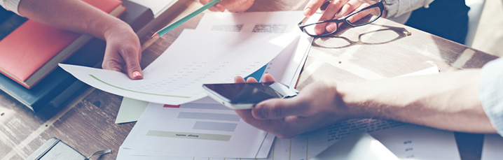 Team meeting with smartphones and spreadsheets