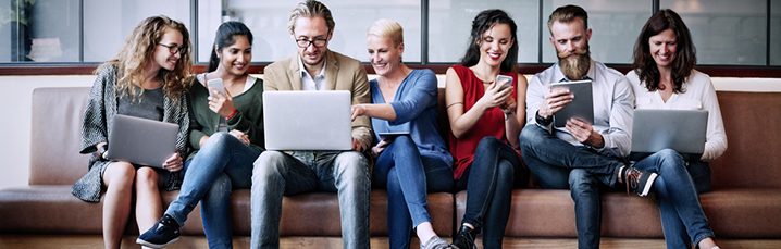 Team working on laptops on a sofa
